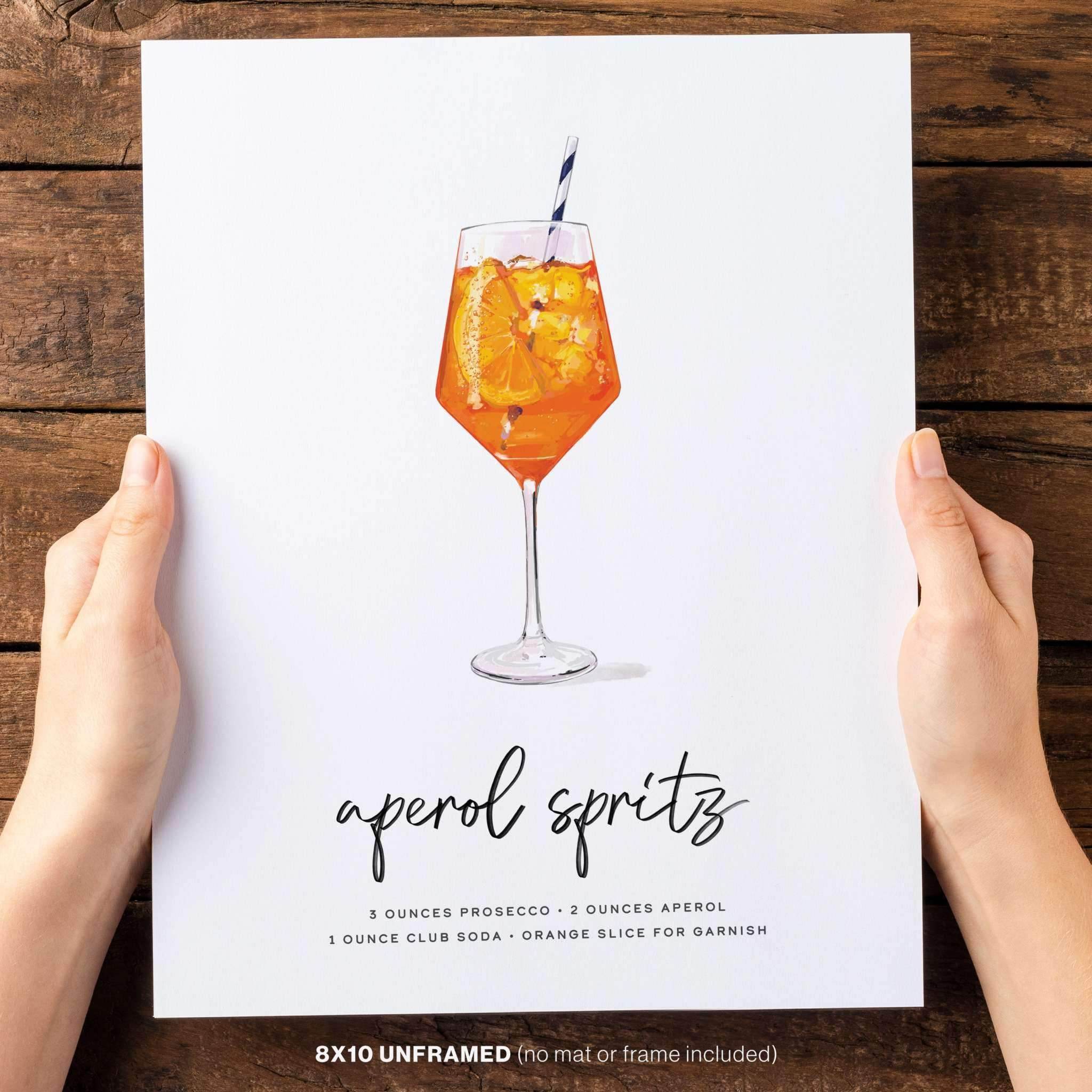 Hands holding an 8x10 Aperol Spritz art print.