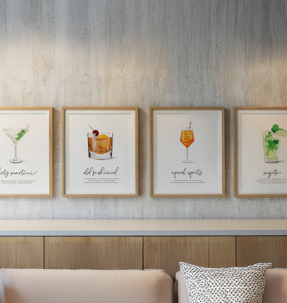 Framed cocktail illustrations on a wall above a sofa.