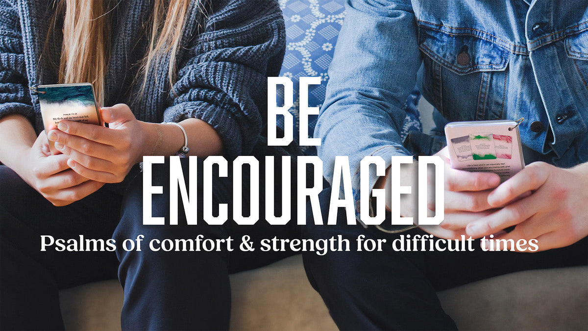 Two people sitting together, each holding Be Encouraged Scripture Cards with Psalms for grief and comfort.