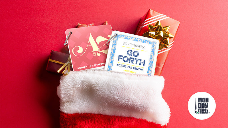 Stocking stuffers including scripture memory cards, Go Forth devotional cards, and wrapped gifts in white Christmas stocking