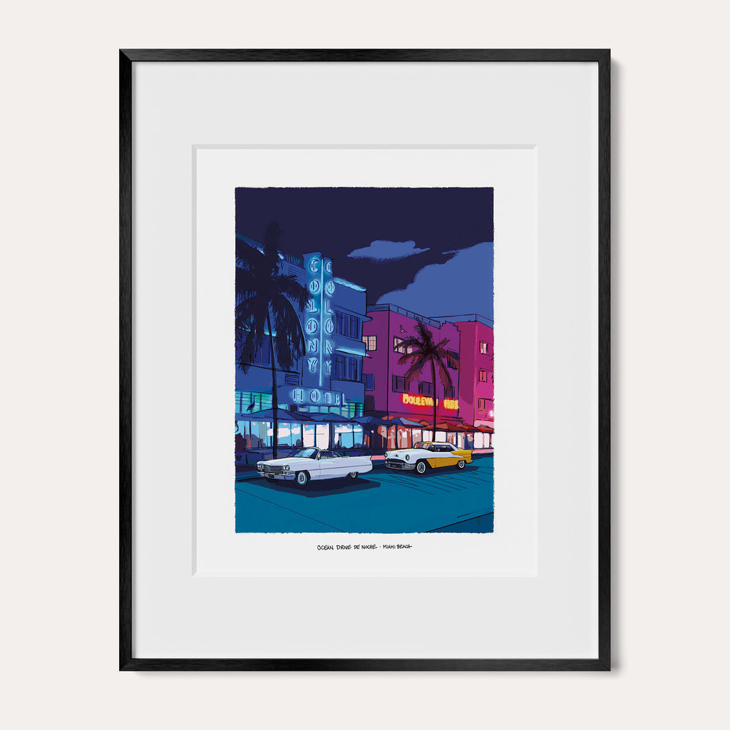 Ocean Drive at Night Miami Beach art print in a black metal frame with a white mat, shown as the 11 x 14 inch frame matted to 8 x 10. The scene shows the Colony Hotel's blue neon sign and the pink Boulevard Hotel at night.