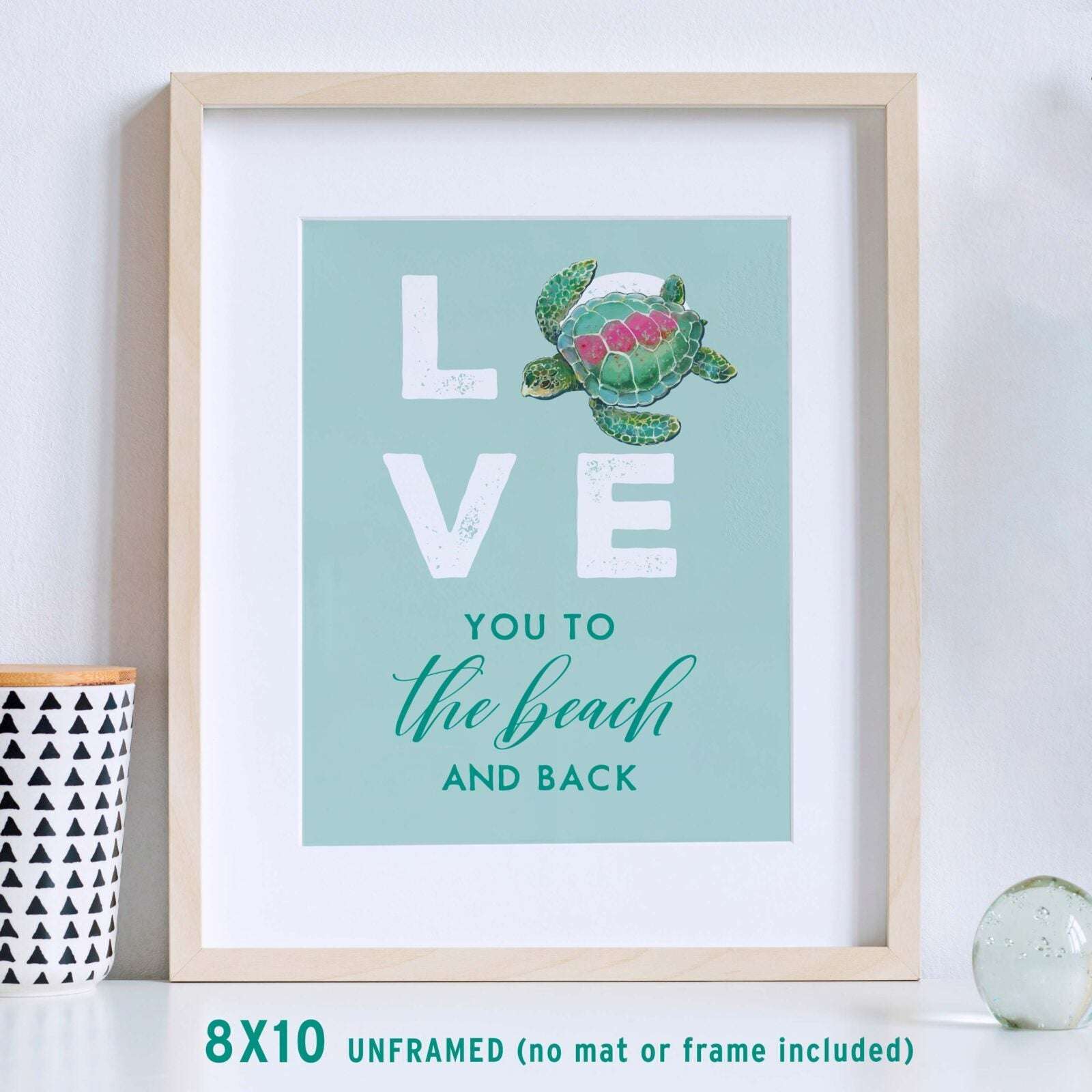 Coastal Home Decor 'Love You To The Beach And Back' Wall Art in maple frame on table with candle.