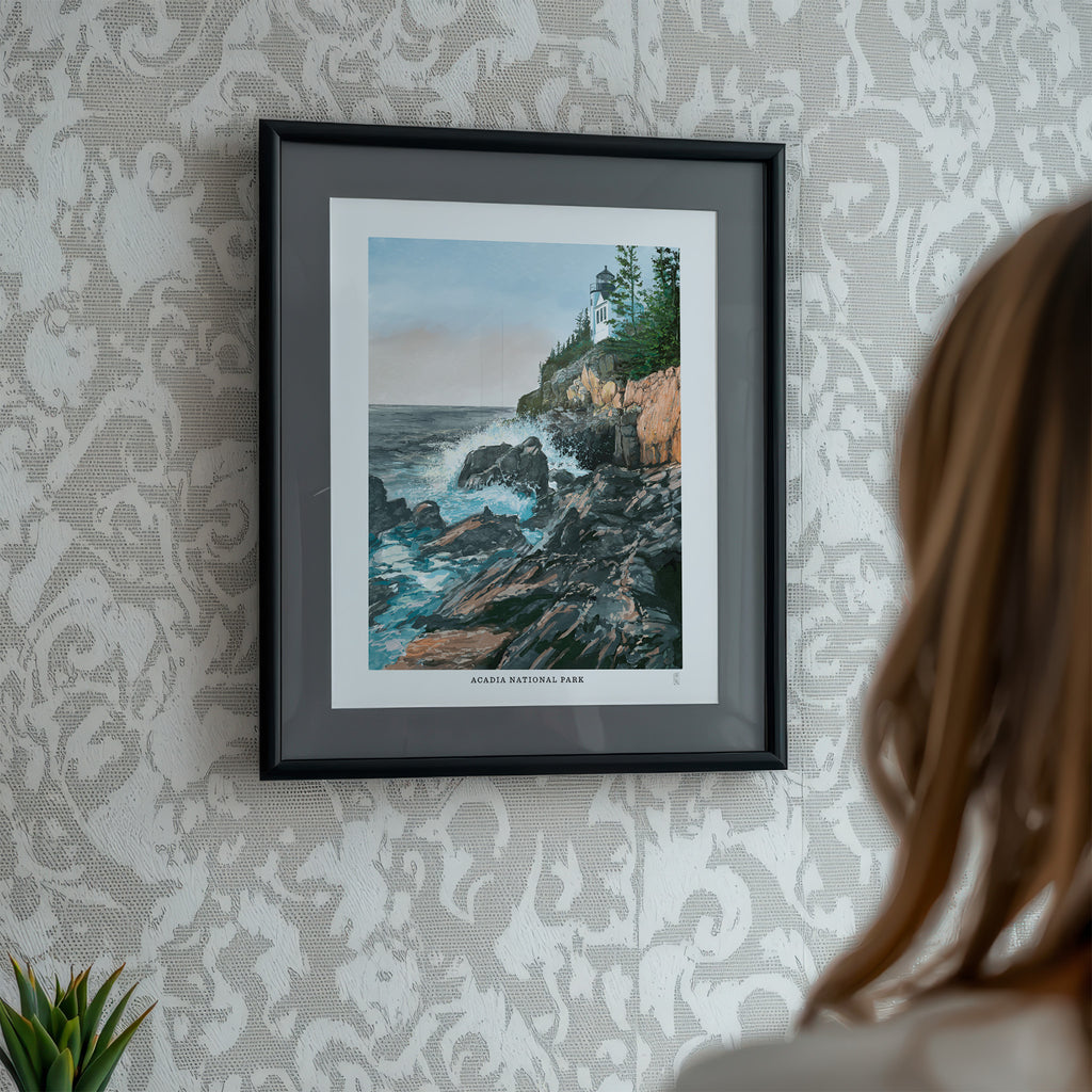 Framed artwork of a Acadia National Park, scene on a wall with a person partially visible.