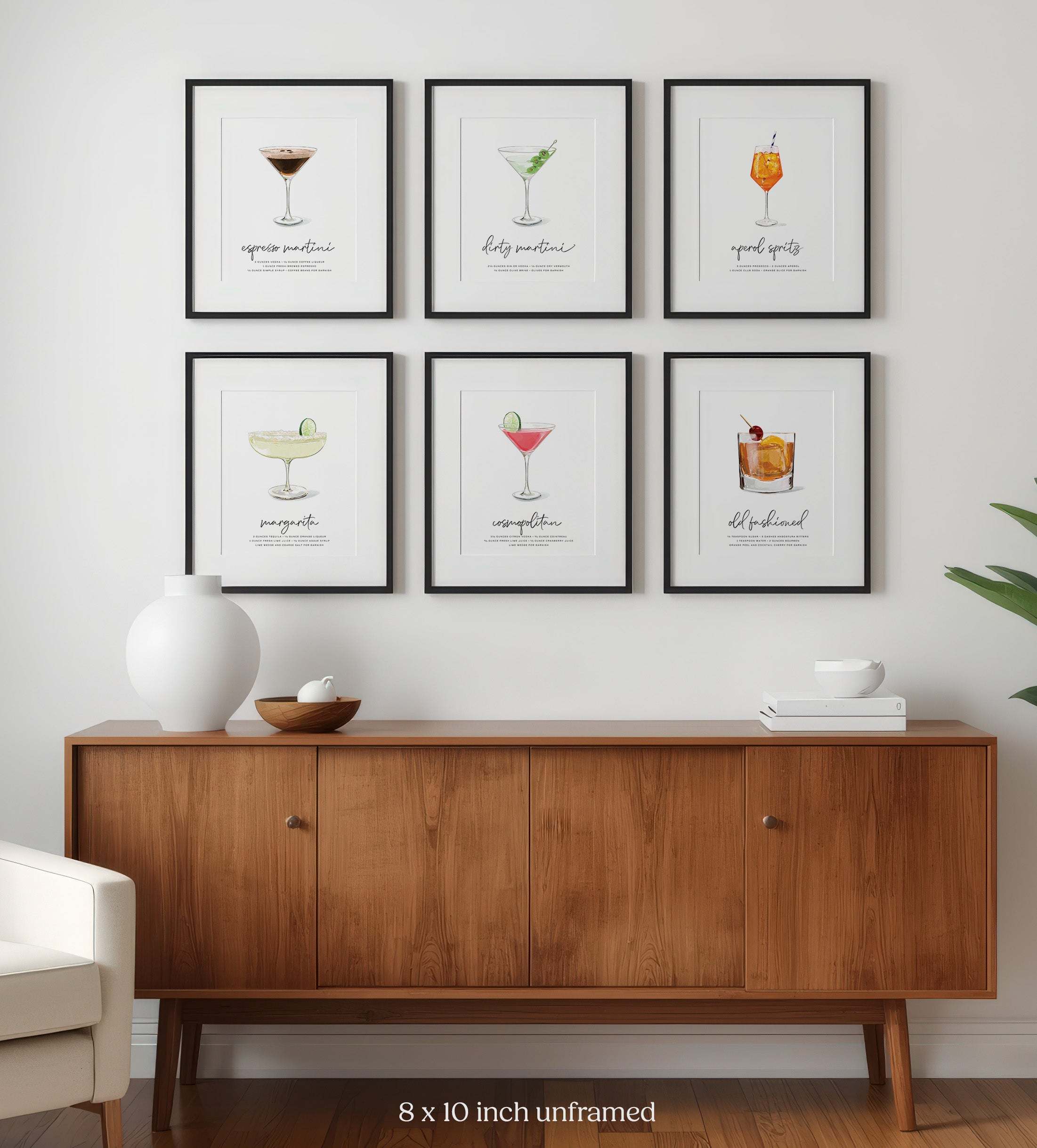 Wooden sideboard with framed cocktail wall art illustrations on a wall