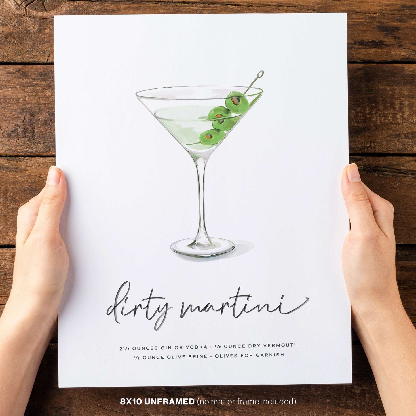 Hand holding our Dirty Martini recipe wall art with olives, 8x10 unframed illustration.
