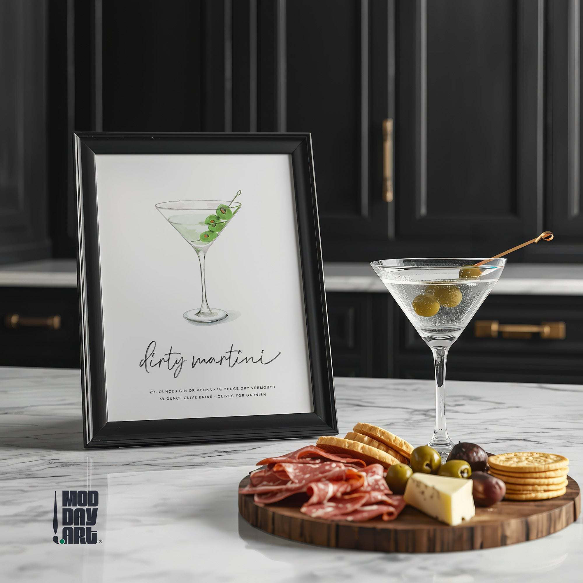 Framed Dirty Martini recipe cocktail wall art on a kitchen counter with a cocktail and charcuterie board.