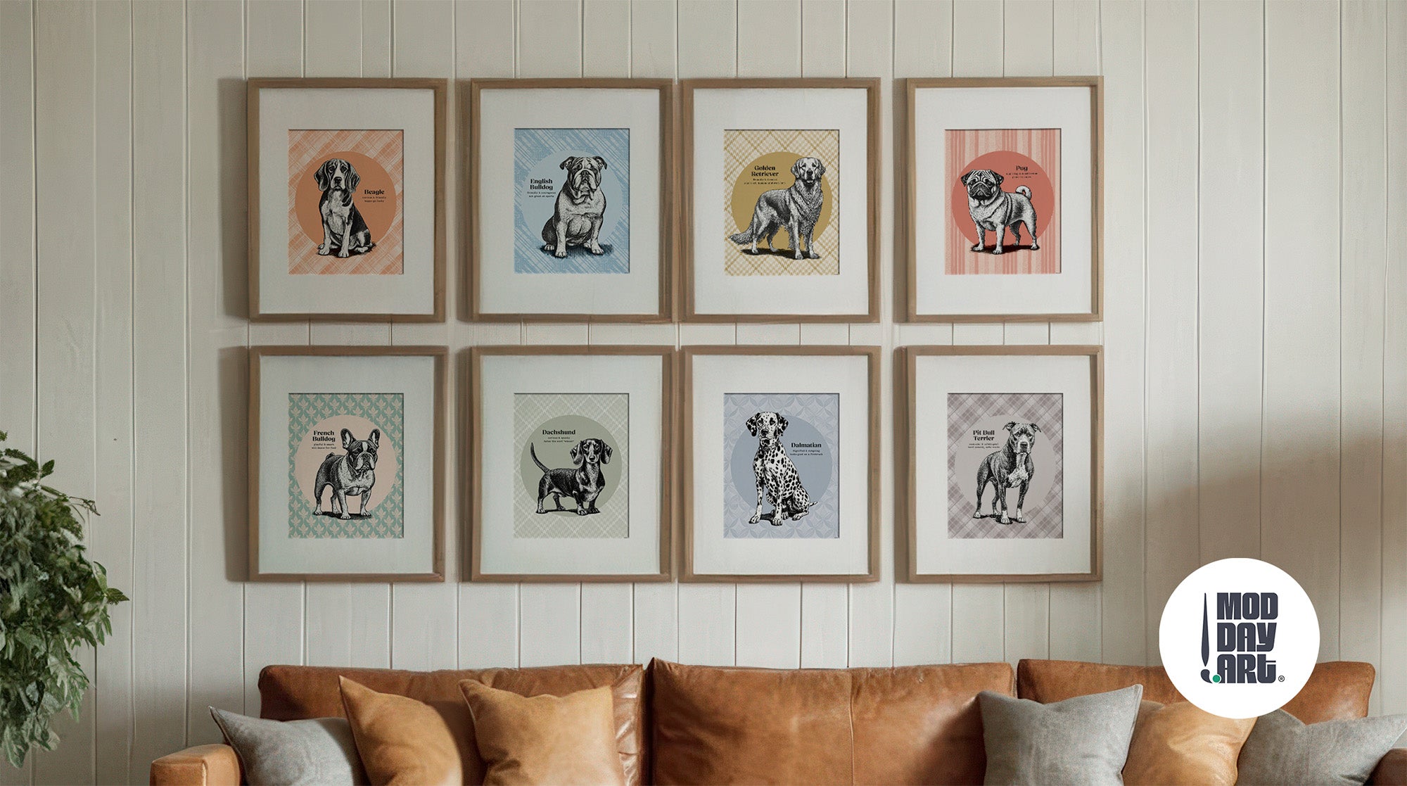 Eight framed vintage dog breed art prints in wood frames arranged in gallery wall above tan leather sofa, featuring Beagle, English Bulldog, Golden Retriever, Pug, French Bulldog, Dachshund, Dalmatian, and Pit Bull illustrations with colorful geometric backgrounds.