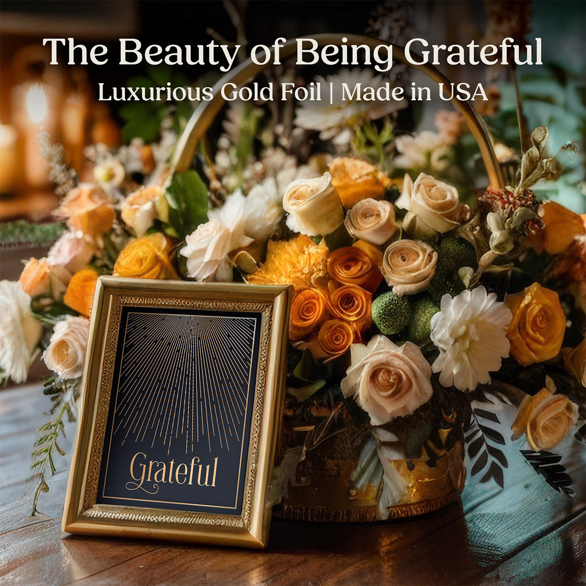 A gold-framed "Grateful" gold foil wall art by Mod Day Art with luxurious gold foil lettering surrounded by autumn flowers including peach and cream roses in an elegant home decor setting.