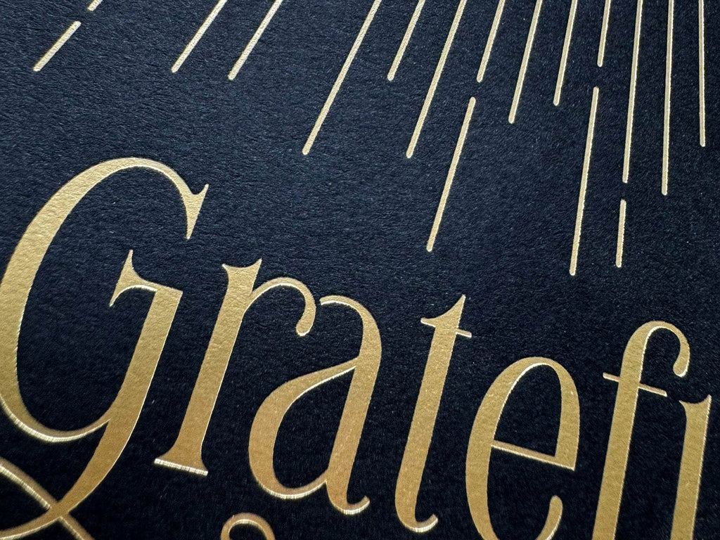 Detailed view of real gold foil typography on grateful wall art - premium metallic finish on black background