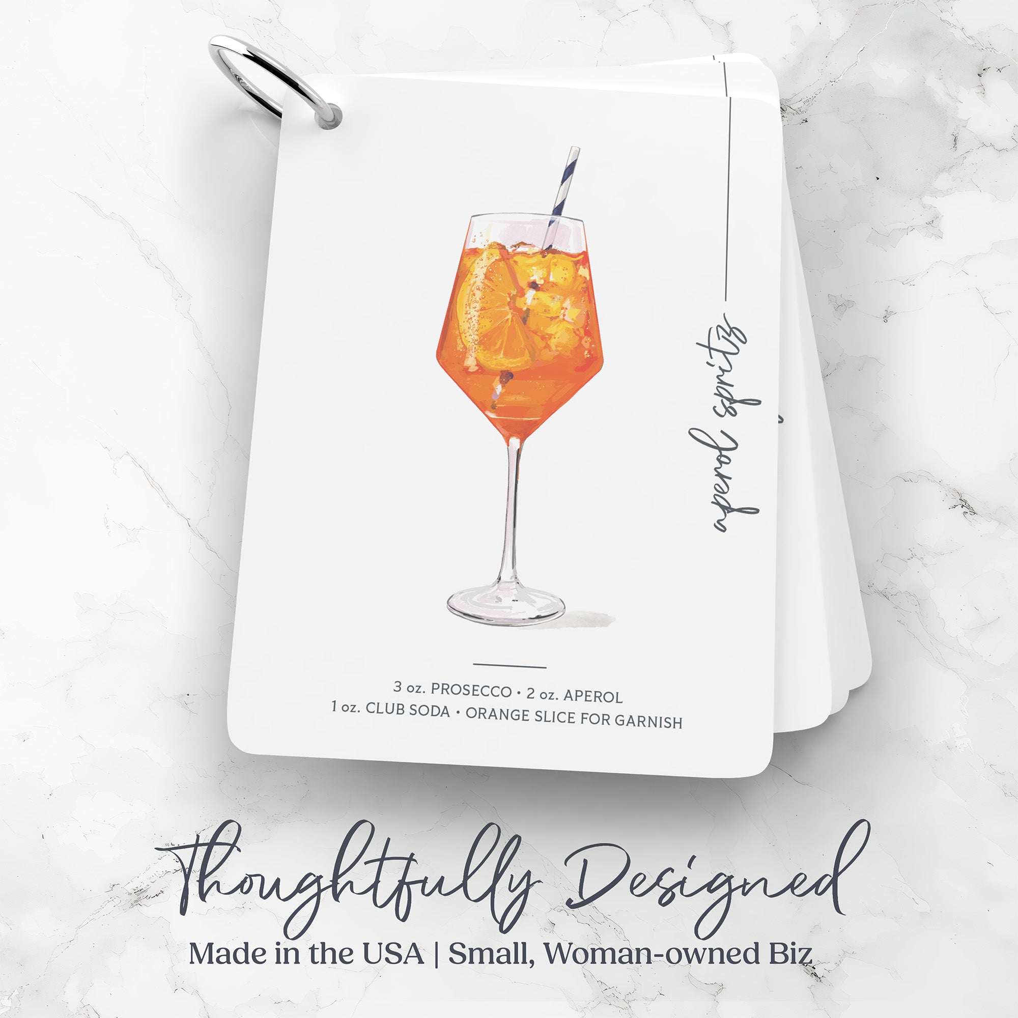 'Illustrated Mixology' Cocktail Flashcards with an Aperol Spritz cocktail illustration and text on a marble surface