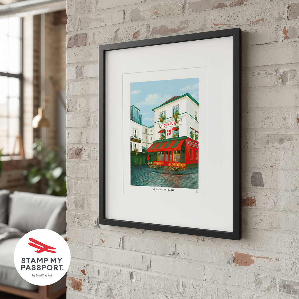 Framed artwork of Le Consulat cafe in Paris on a white wall with 'Stamp My Passport' logo.
