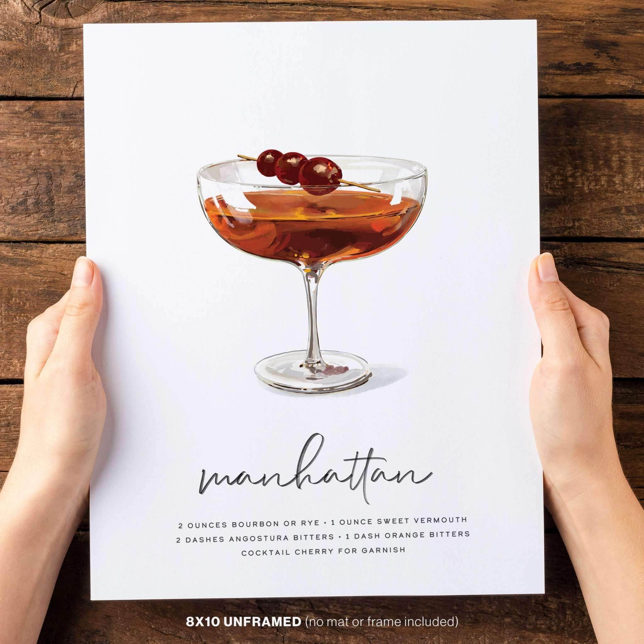 Two hands holding hand-drawn Manhattan Cocktail Wall Art.