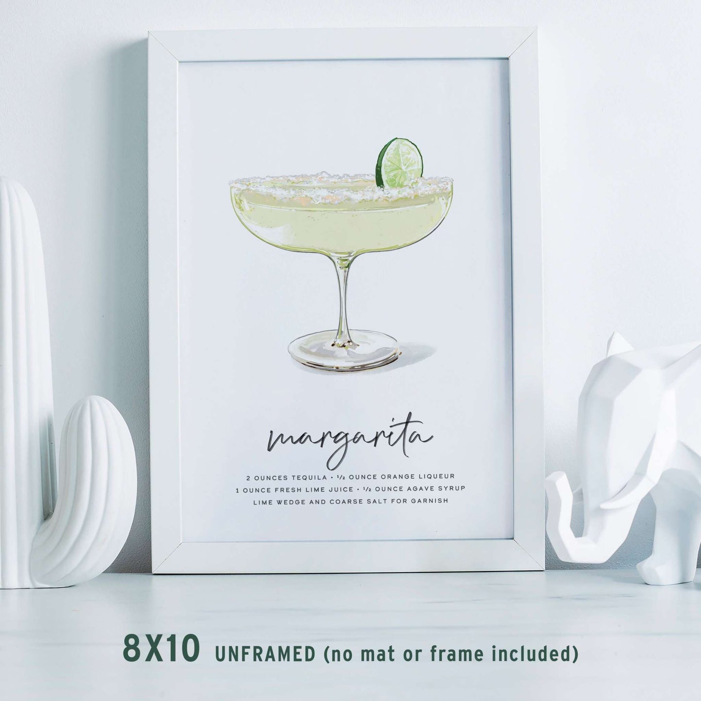 Margarita Recipe Wall Art displayed in a frame on a table, accented with stylish white home decor accessories for a modern touch.