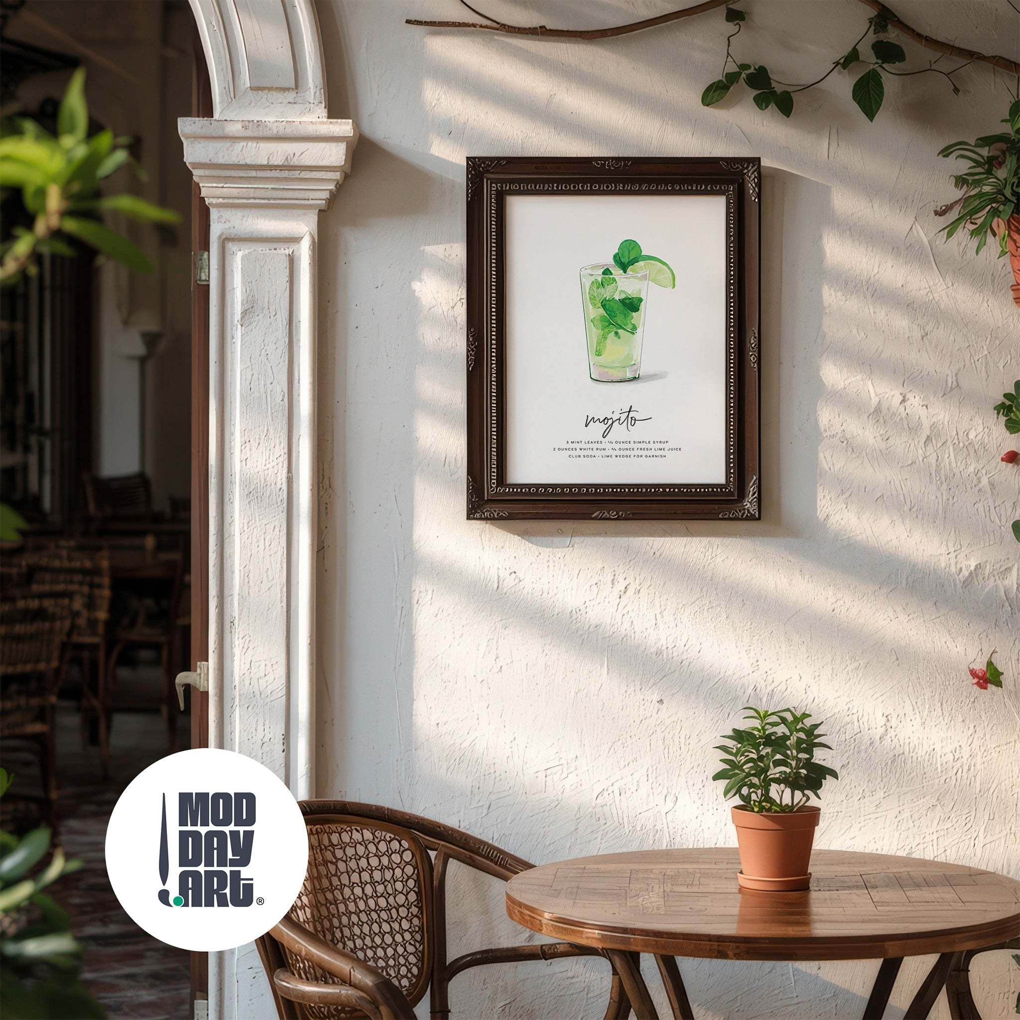 Framed artwork of a mojito recipe cocktail poster on a wall in a cozy indoor setting with a plant and chair.