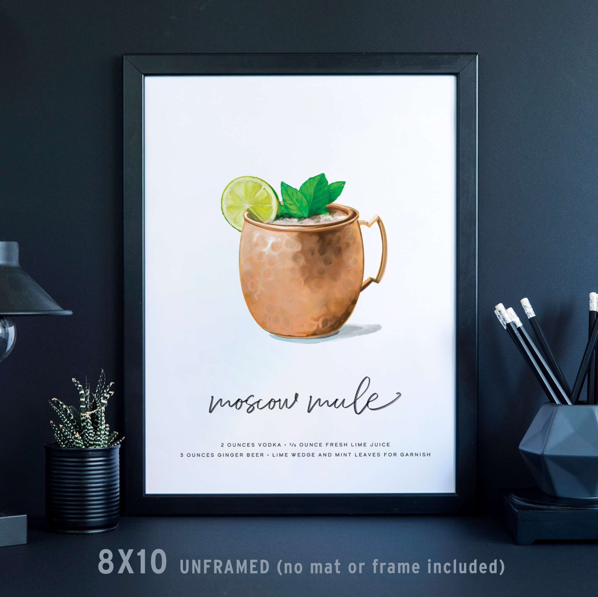 Moscow Mule cocktail wall art in a black frame, featuring an illustration of a copper mug with lime and mint garnish, 8x10 inches.