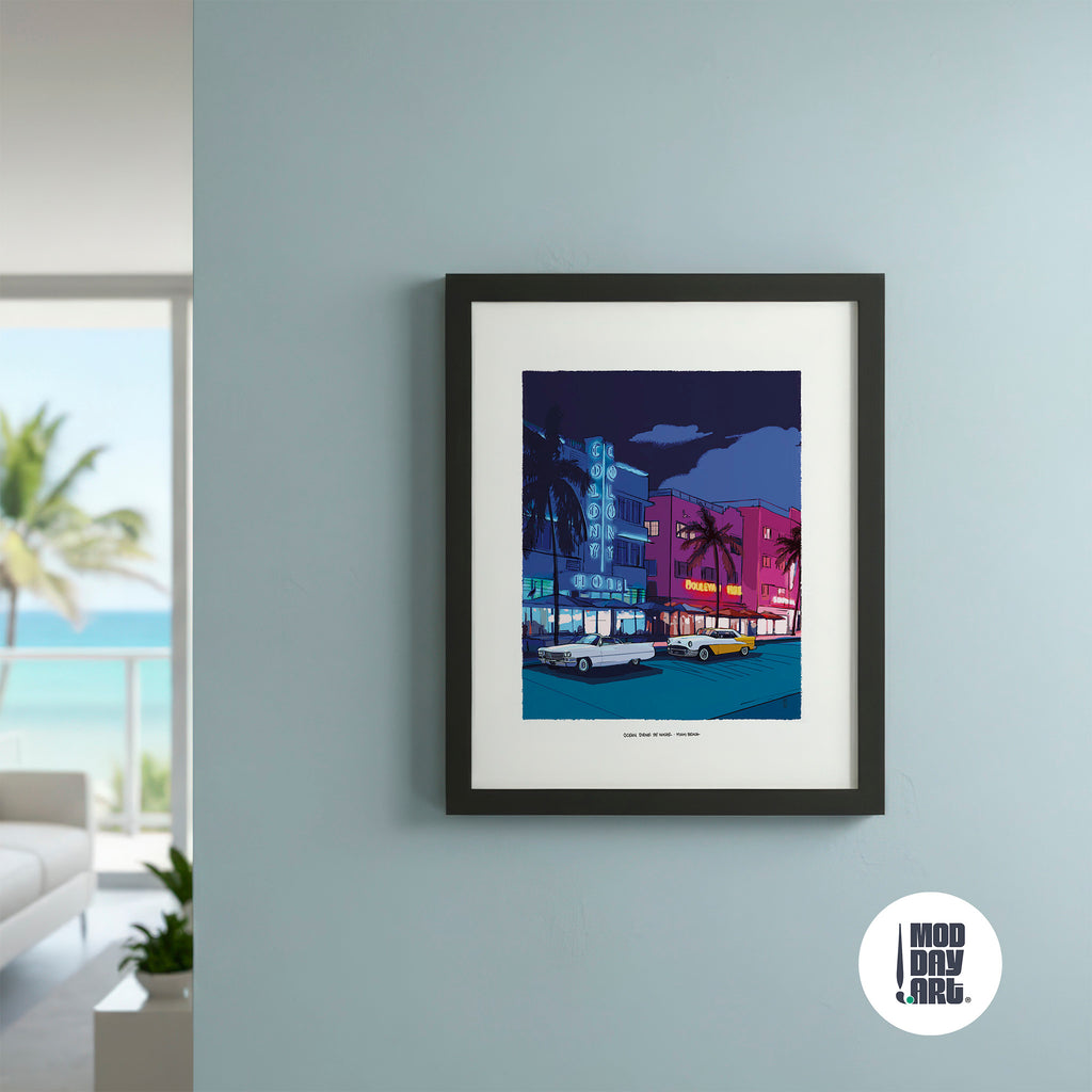 A framed art print featuring a colorful retro illustration of Miami Beach at night, hung on a light blue-gray wall in a modern room setting. The print has a white mat and a black frame, with a circular 'MOD DAY ART.