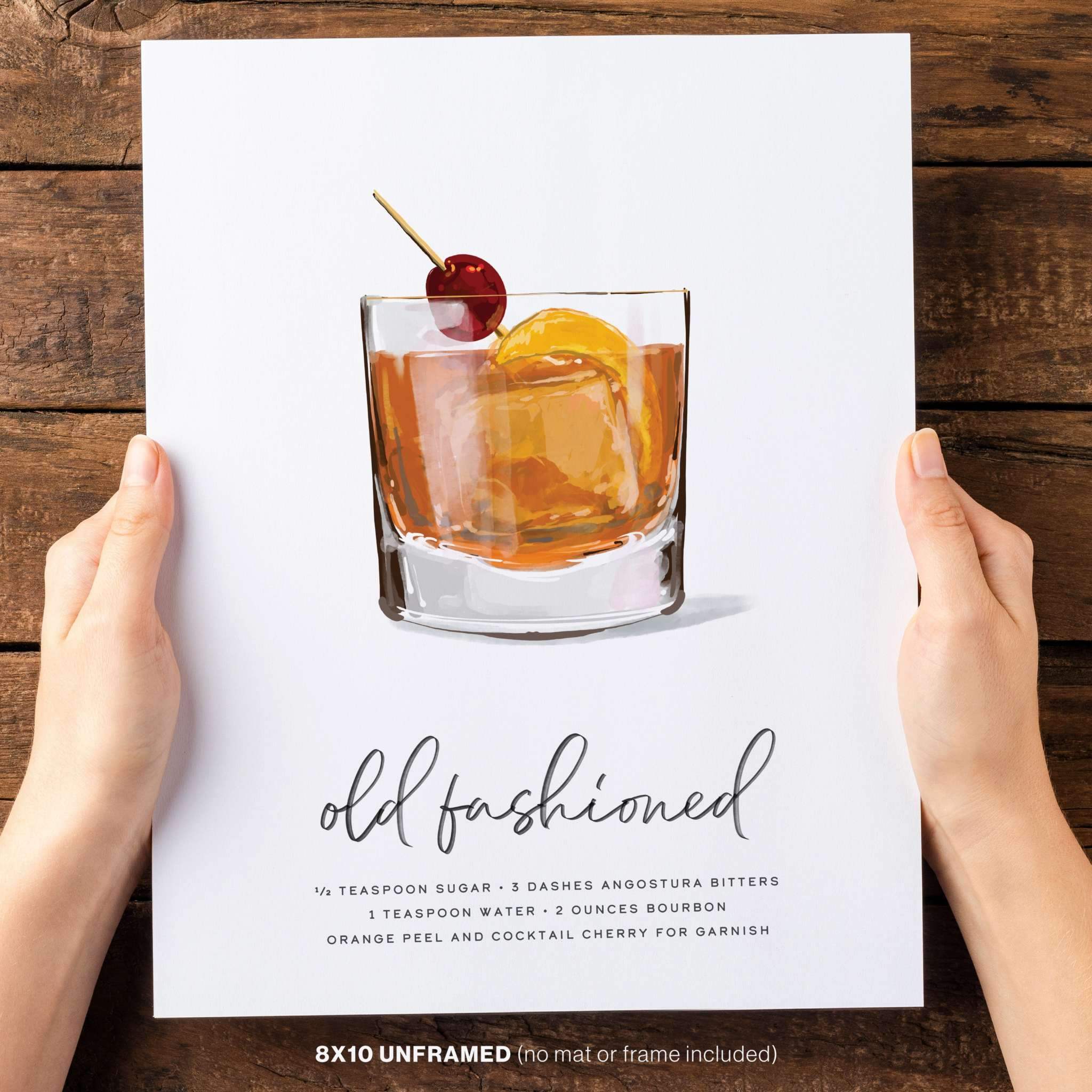 Two hands holding an 8x10 Old Fashioned cocktail poster, showcasing its stylish design and compact size.