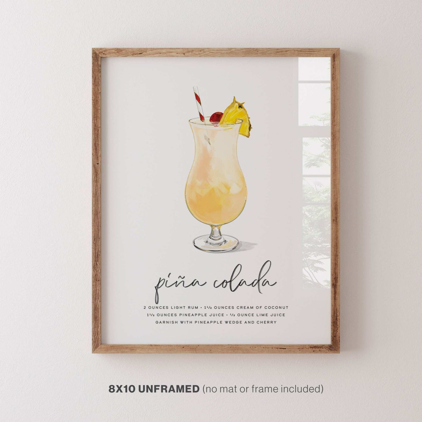 Piña Colada cocktail wall art, 8x10 inches, displayed in a frame on a wall for stylish decor.