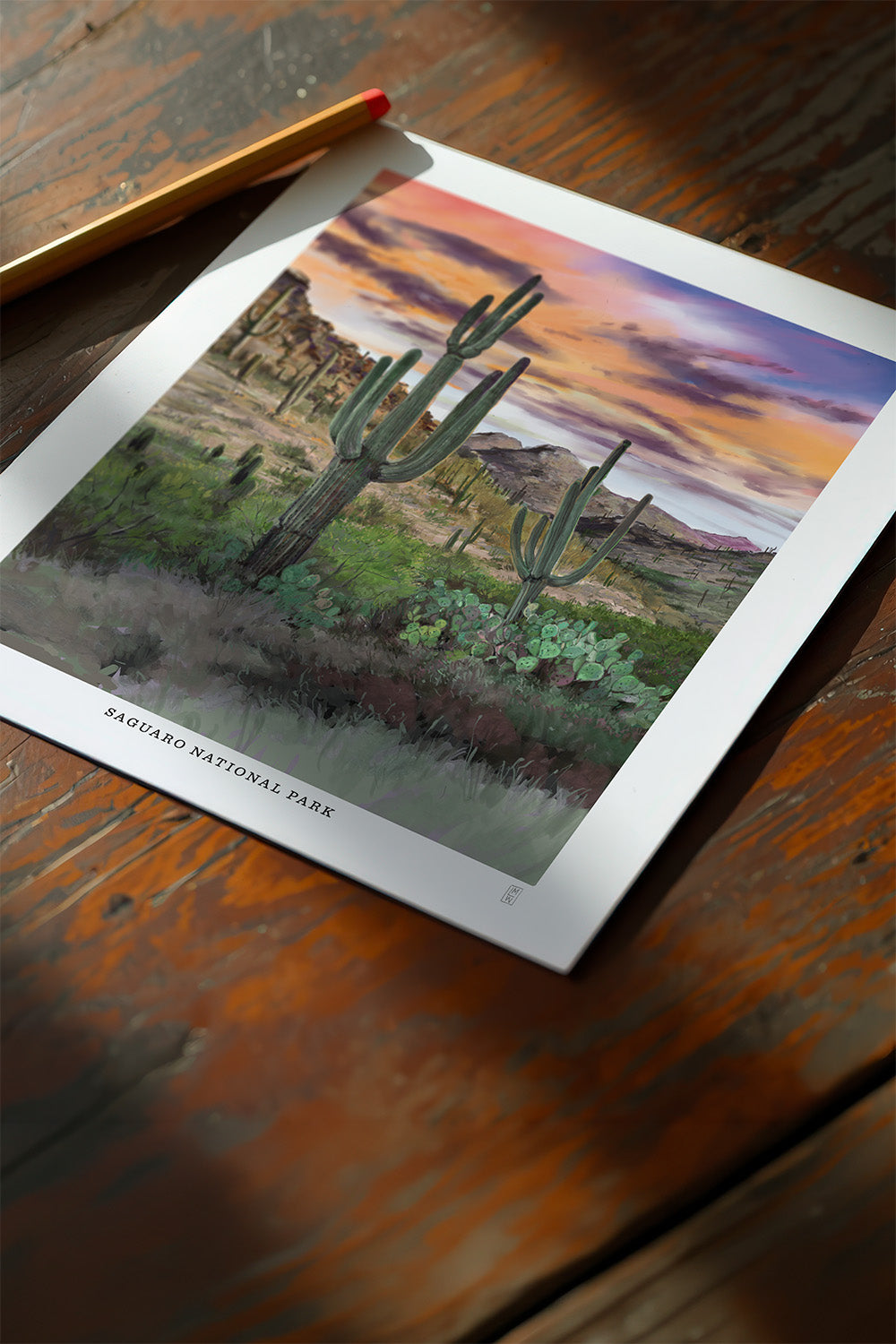 Print of  Saguaro National Park poster hand-signed by the artist featuring a desert landscape with cacti on a wooden surface
