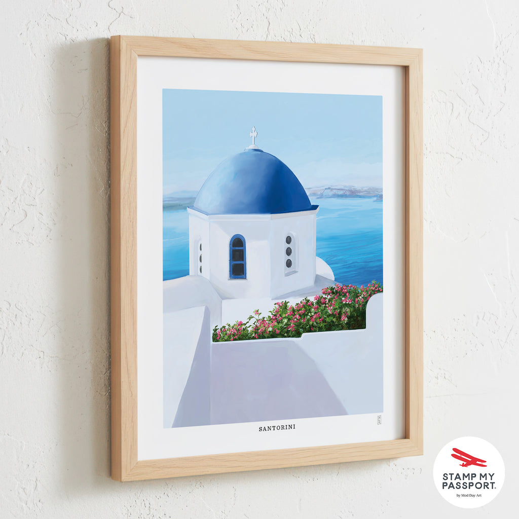 Framed hand-signed travel wall art print  of a blue-domed church in Santorini with 'Stamp My Passport' logo.