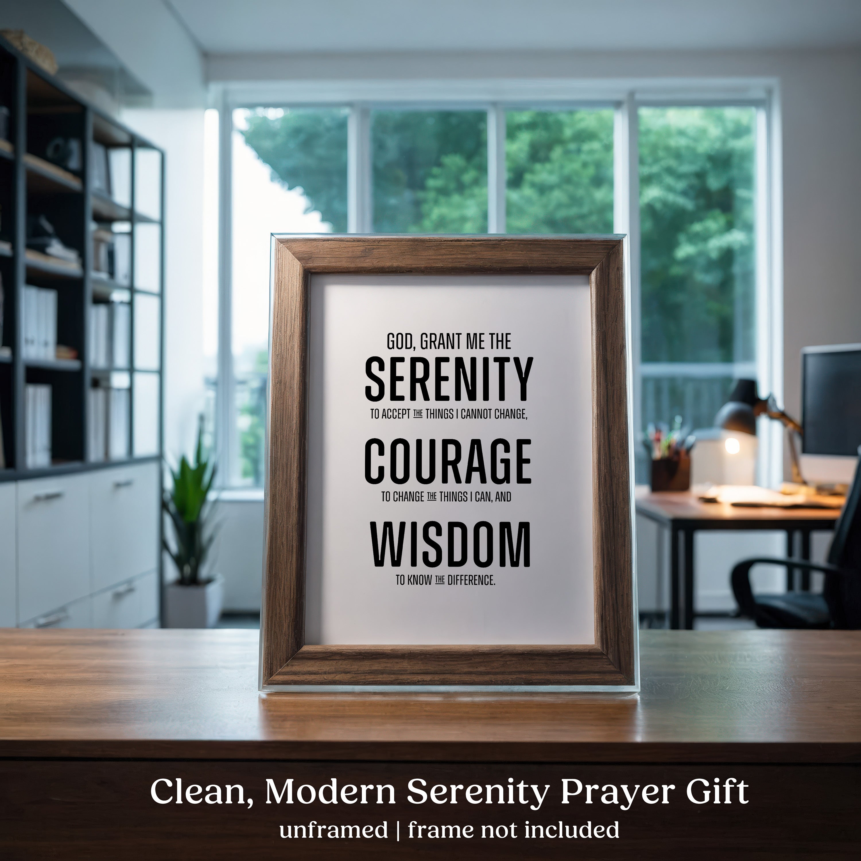 Framed Serenity Prayer print on a desk with a blurred office background