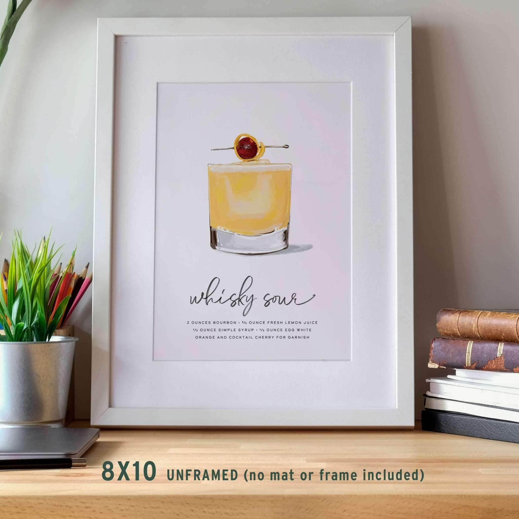 Whiskey Sour Recipe Wall Art displayed in a modern wood frame, leaning against a wall on a small table for a stylish and cozy presentation.